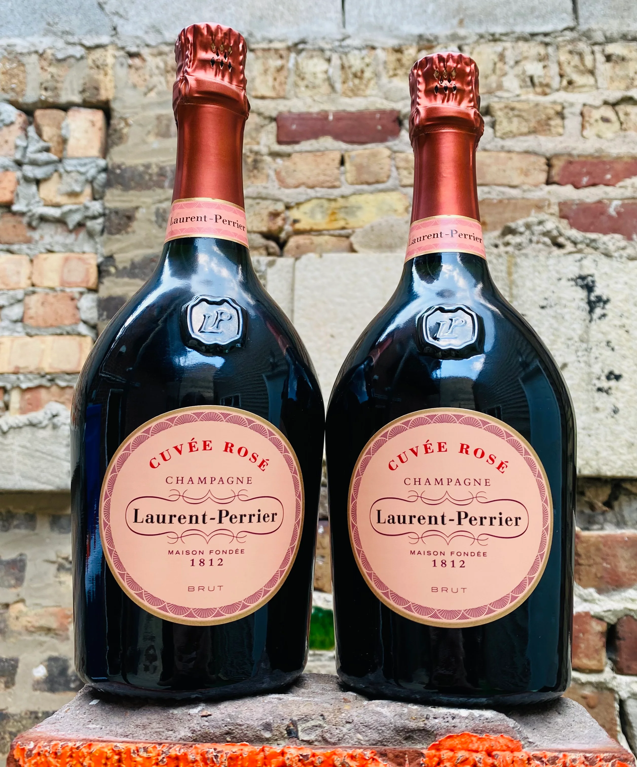 A bottle of Laurent Perrier Rose champagne on a table.