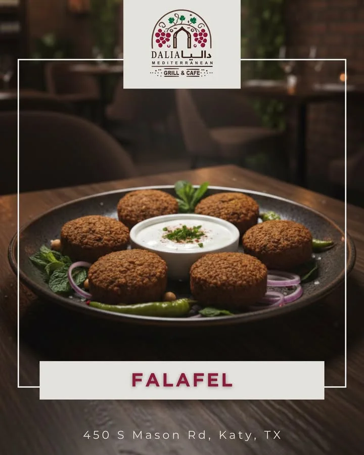 A plate of falafel balls served with a side of tahini sauce and garnished with fresh herbs.