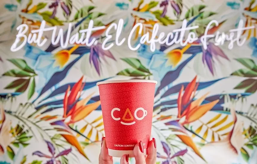Colorful coffee cup in front of tropical mural
