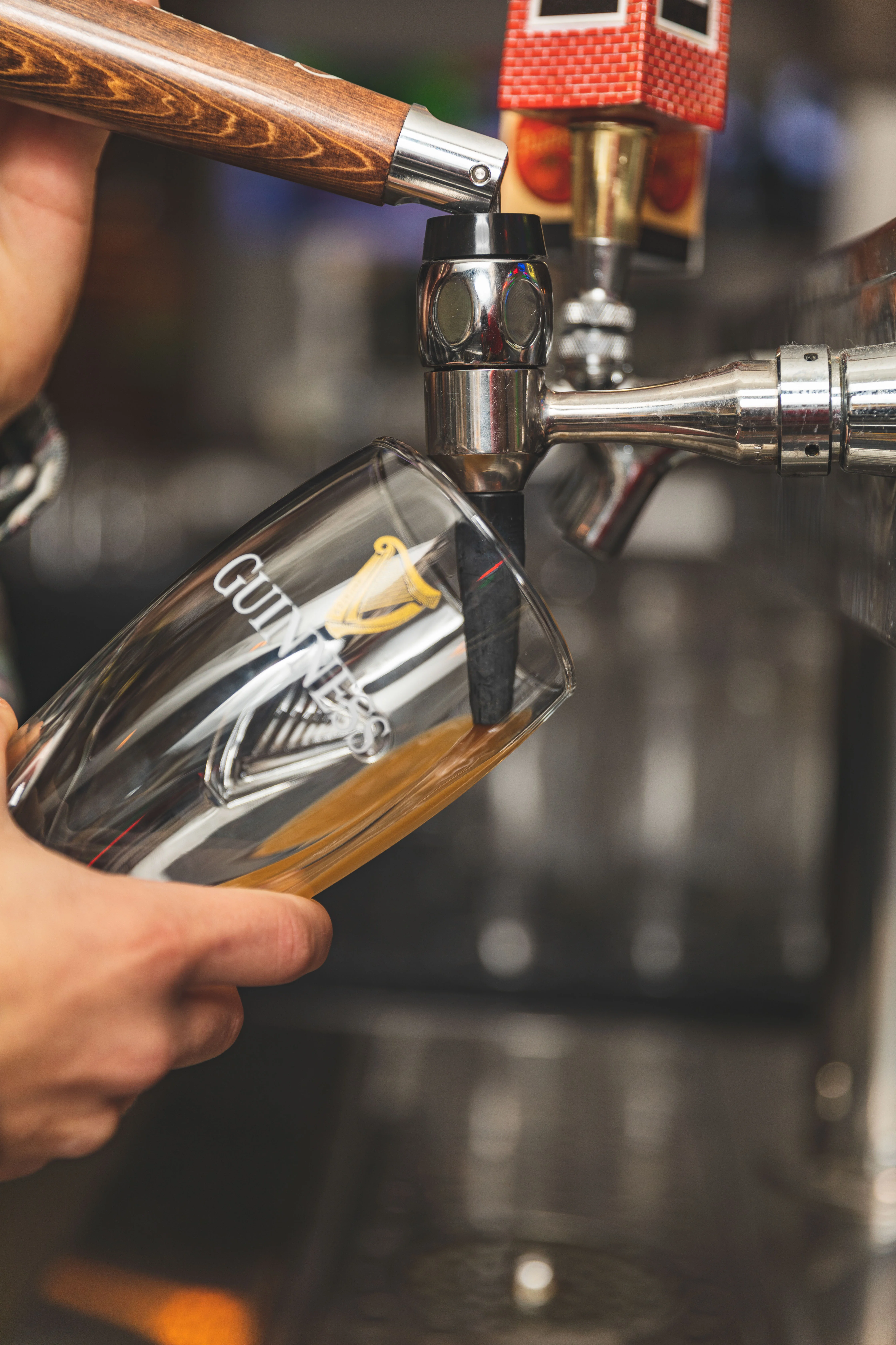 Bartender pouring a pint of Guinness at a bar