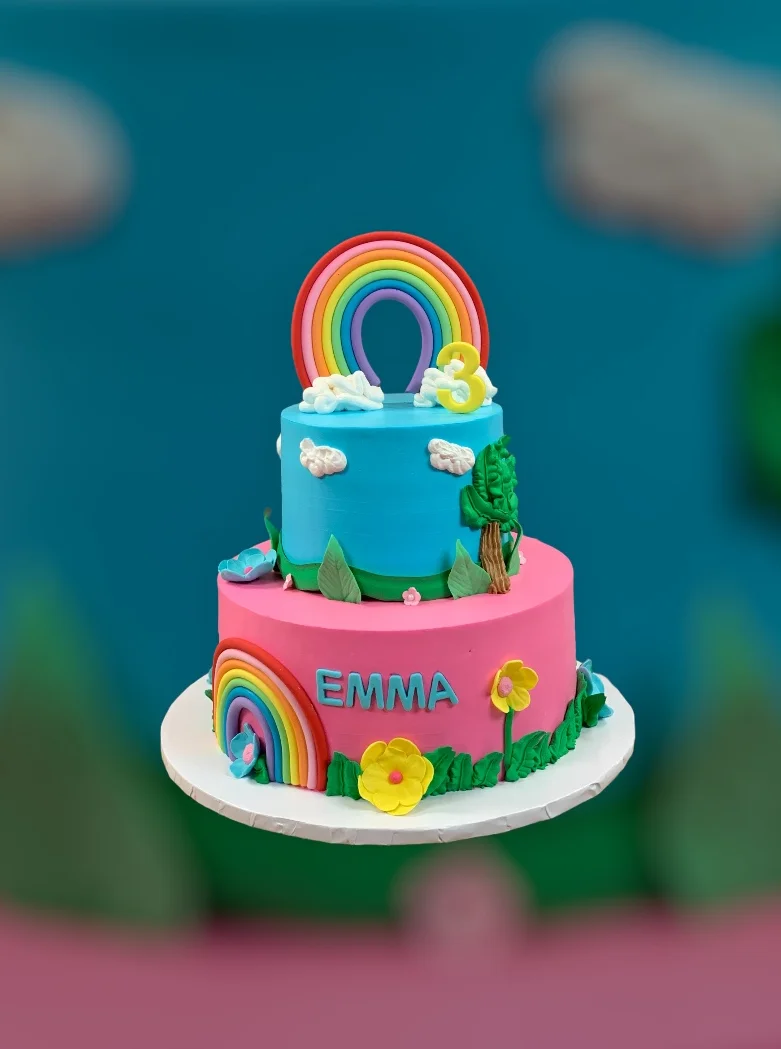 Colorful birthday cake with rainbows and flowers for a child's celebration