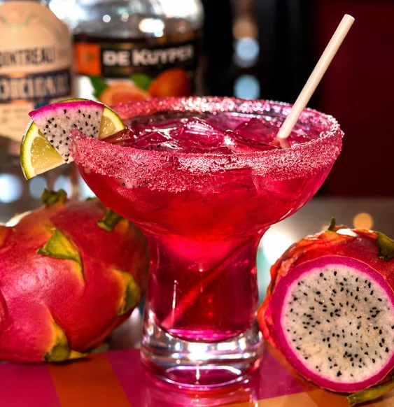 Vibrant dragon fruit margarita cocktail with lime garnish