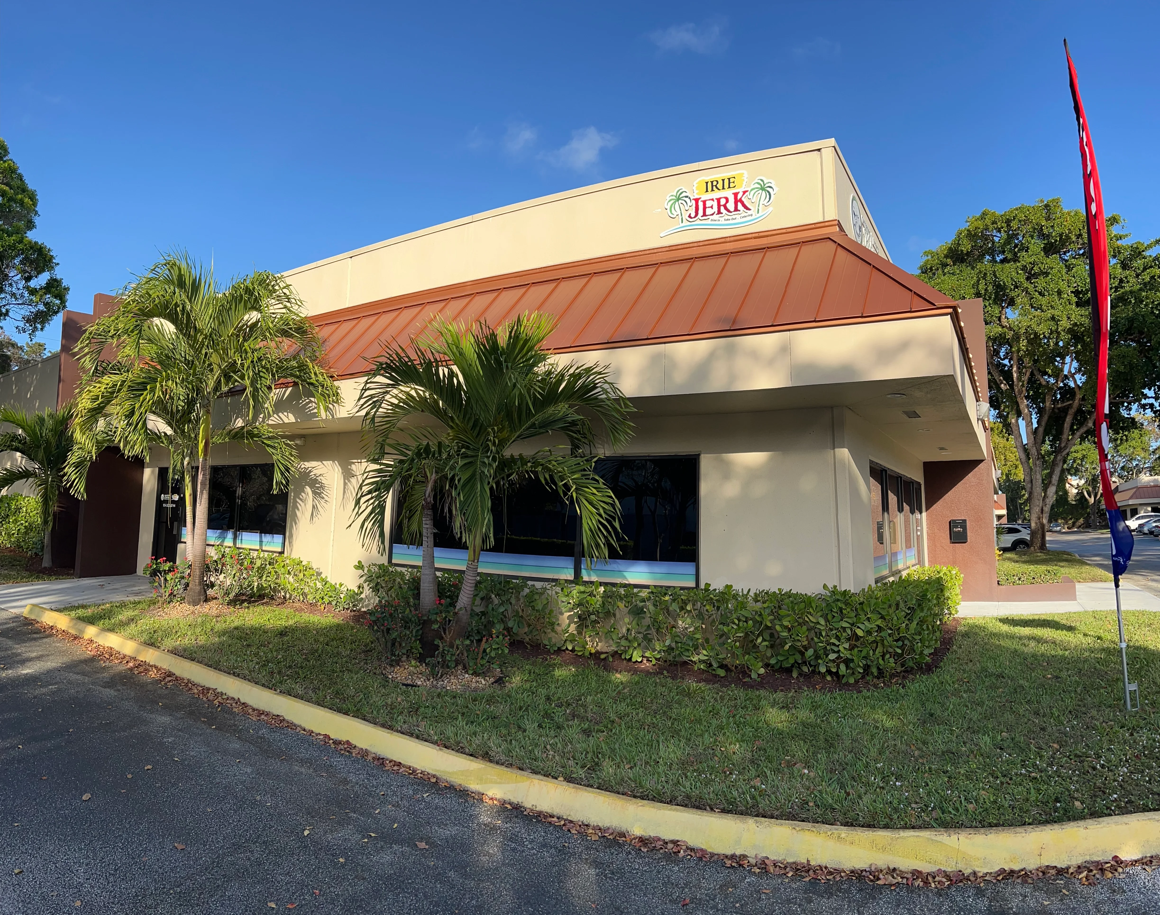 Exterior view of Irie Jerk restaurant with tropical landscaping