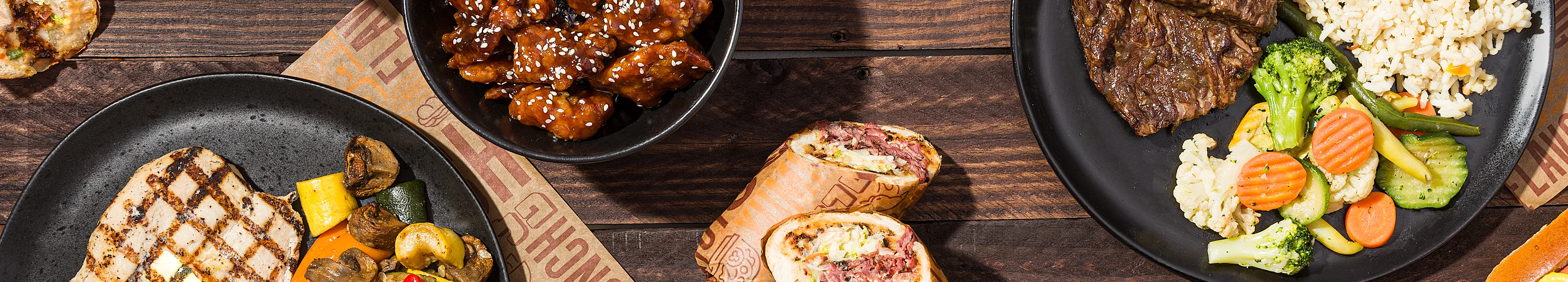 Grilled chicken and beef dishes with Asian-inspired sides and a hot dog