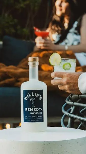 Chic outdoor setting with cocktails and infused spirit bottle on a table