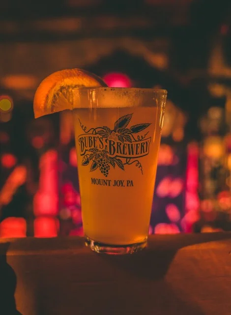 Craft beer in a glass with limes and brewery growlers