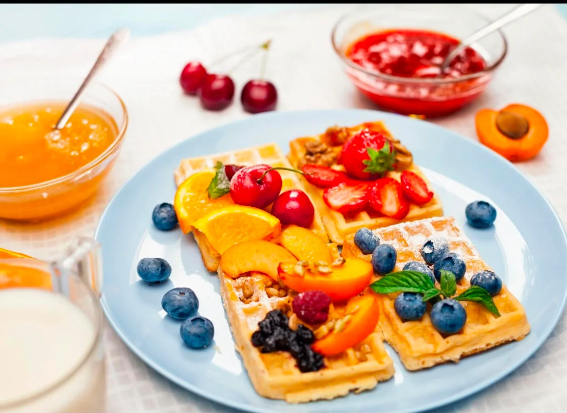 Delicious Belgian waffles topped with fresh fruits and jams