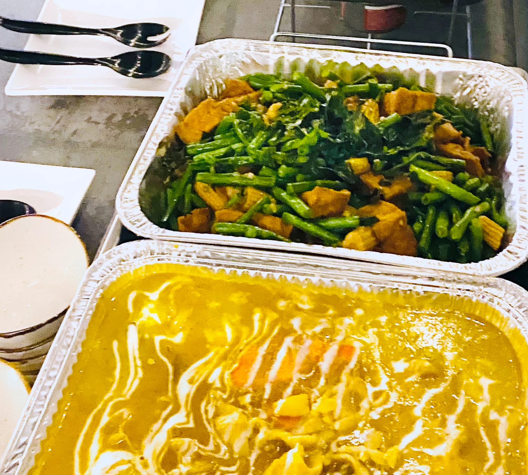 Assorted Chinese dishes in aluminum trays for a buffet