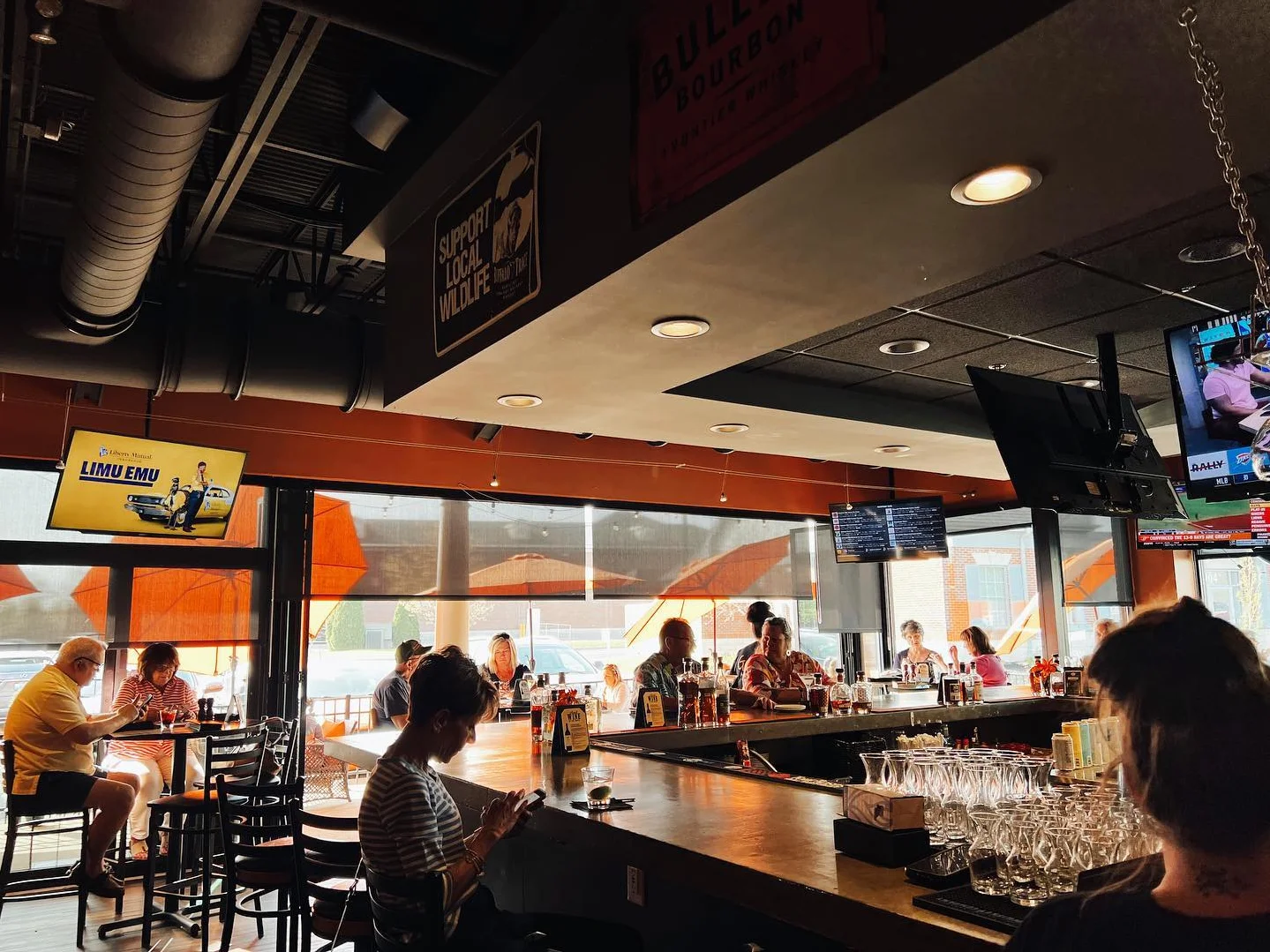 Modern bar interior with patrons enjoying drinks and a lively atmosphere