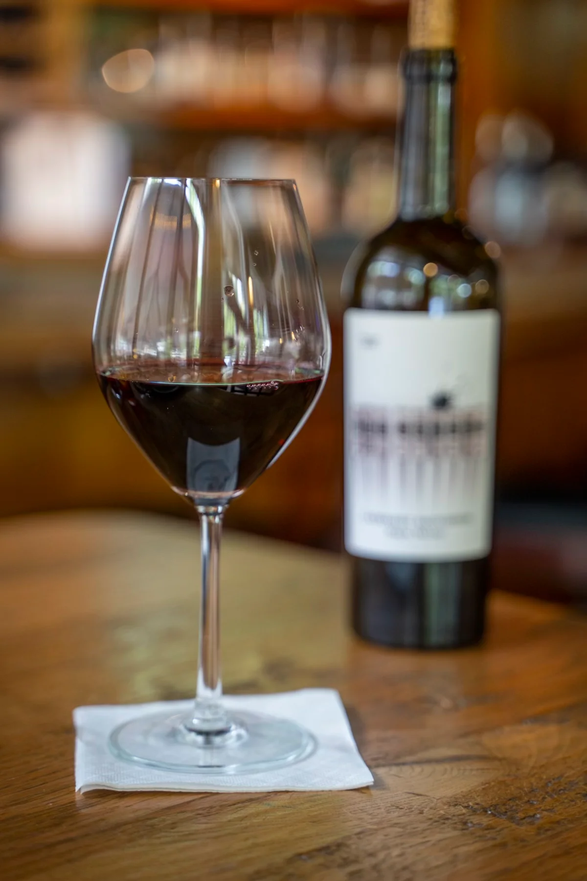 Glass of red wine with a bottle at Crave Kitchen & Cocktails
