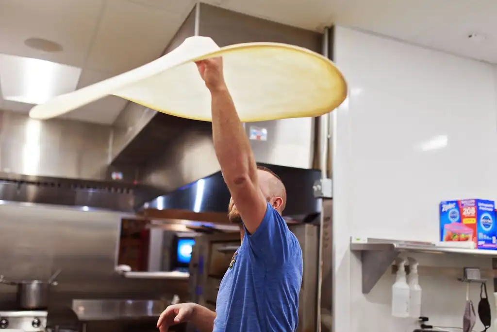 Dough master tossing pizza dough