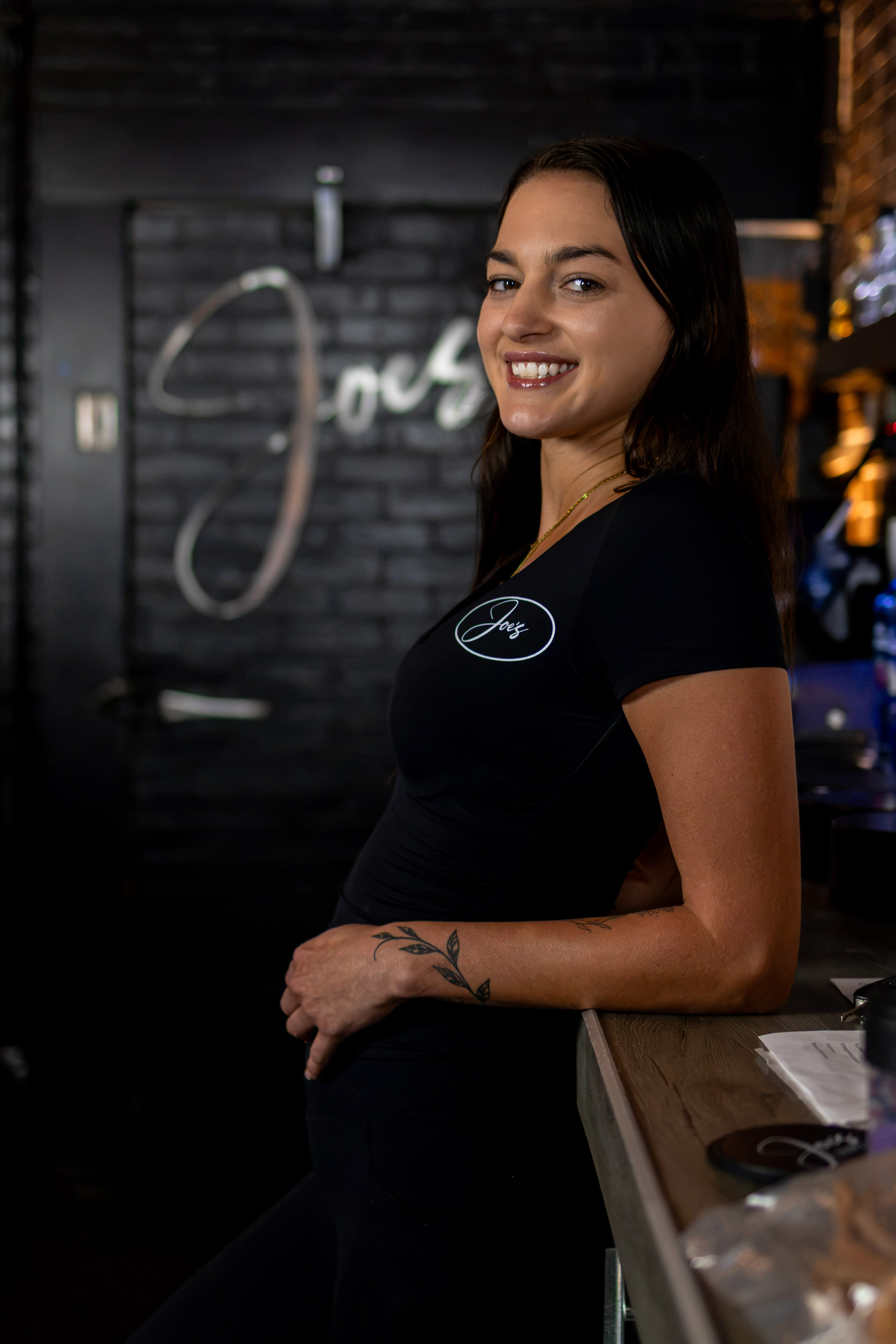 Smiling restaurant staff member in a dimly lit dining area