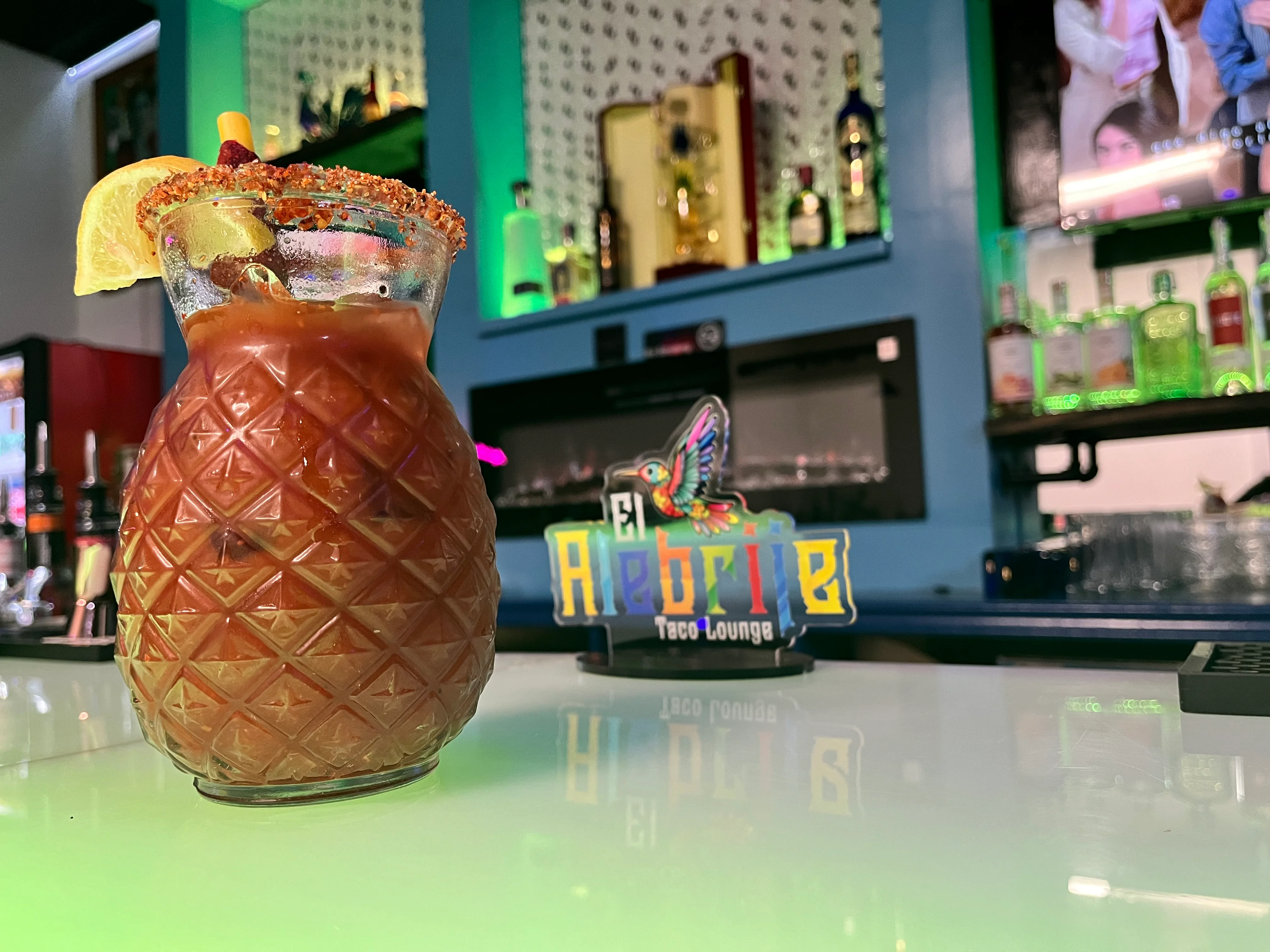 Colorful cocktail served in a pineapple glass at a vibrant bar