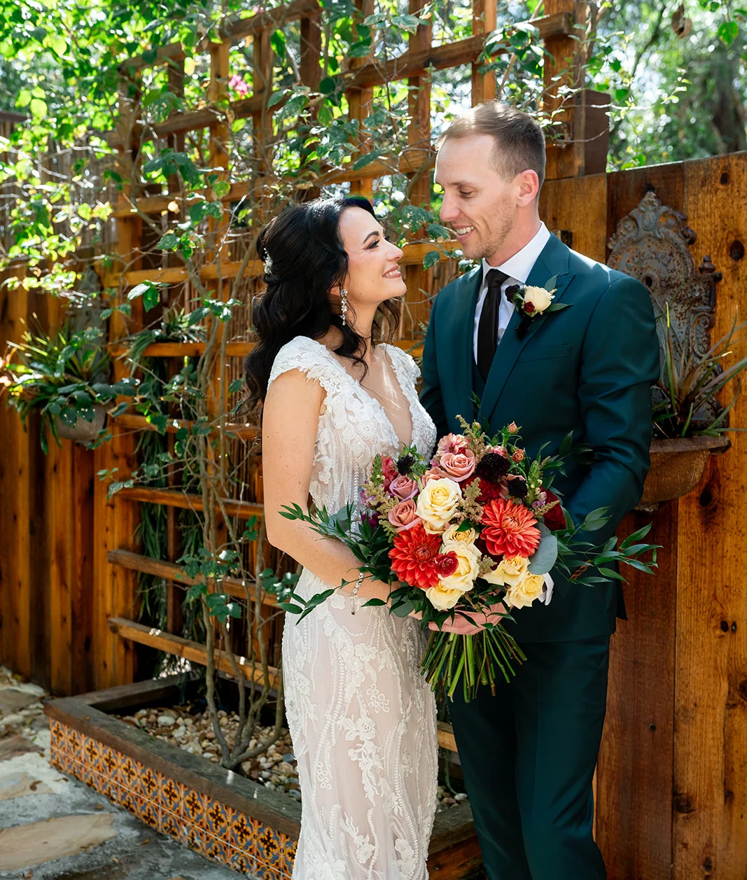 Bride and groom smiling in a lush garden setting