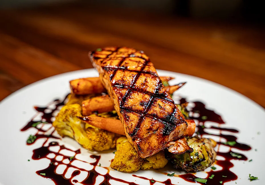 Colorful salads, bowls, and fresh healthy dishes like our Salmon Al Forno at Noosh Nosh in Louisville’s Clifton neighborhood, including vegetarian, vegan, and gluten‑free options made daily.