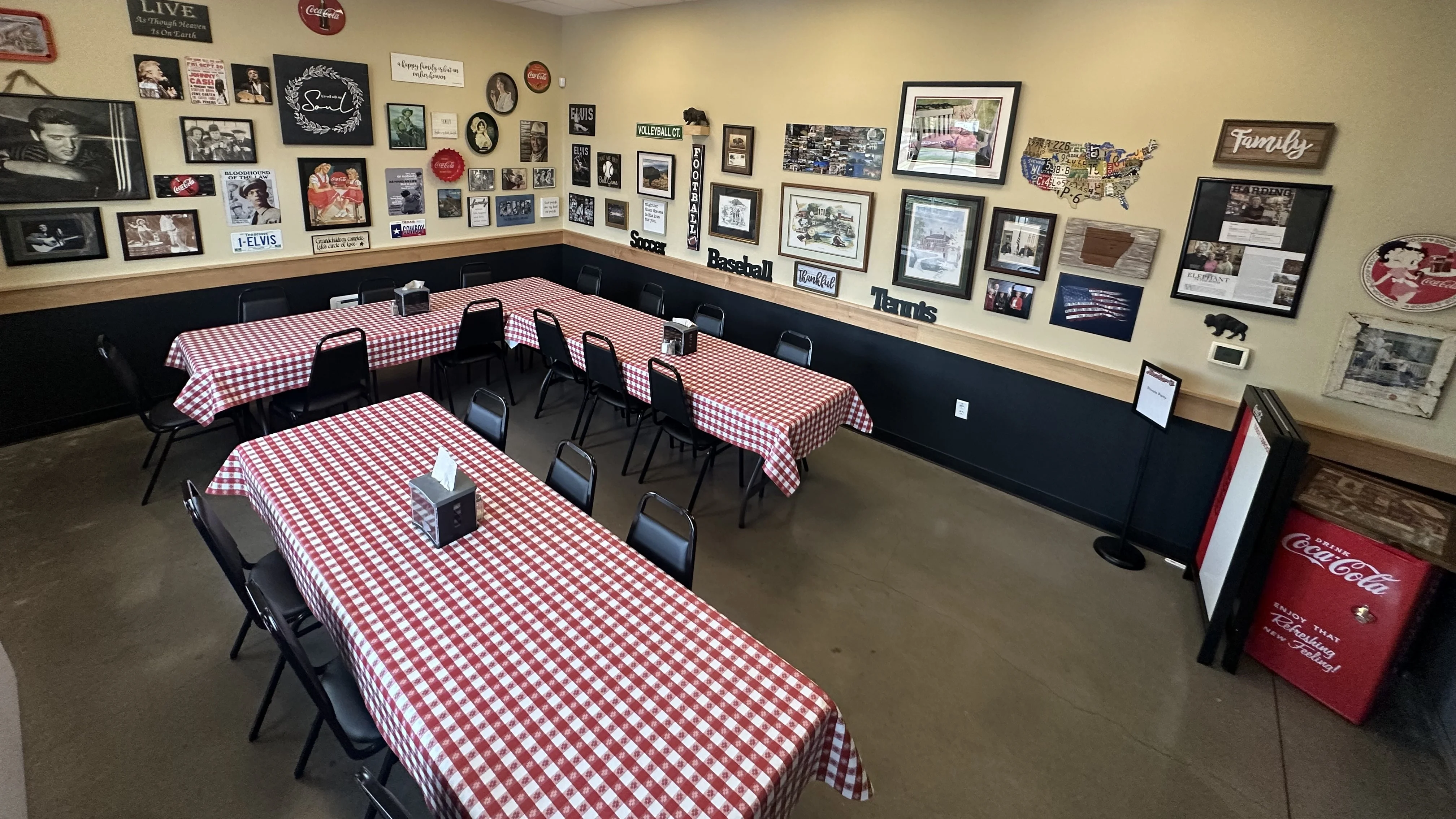 Interior of a restaurant with checkered tables and wall decor.