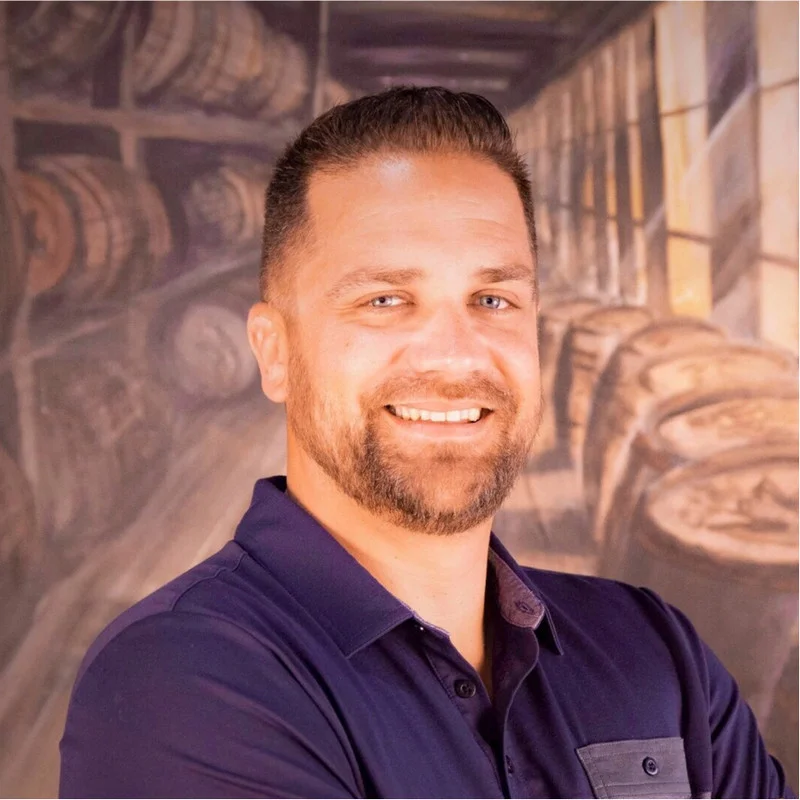 Smiling man in a restaurant with barrels in the background