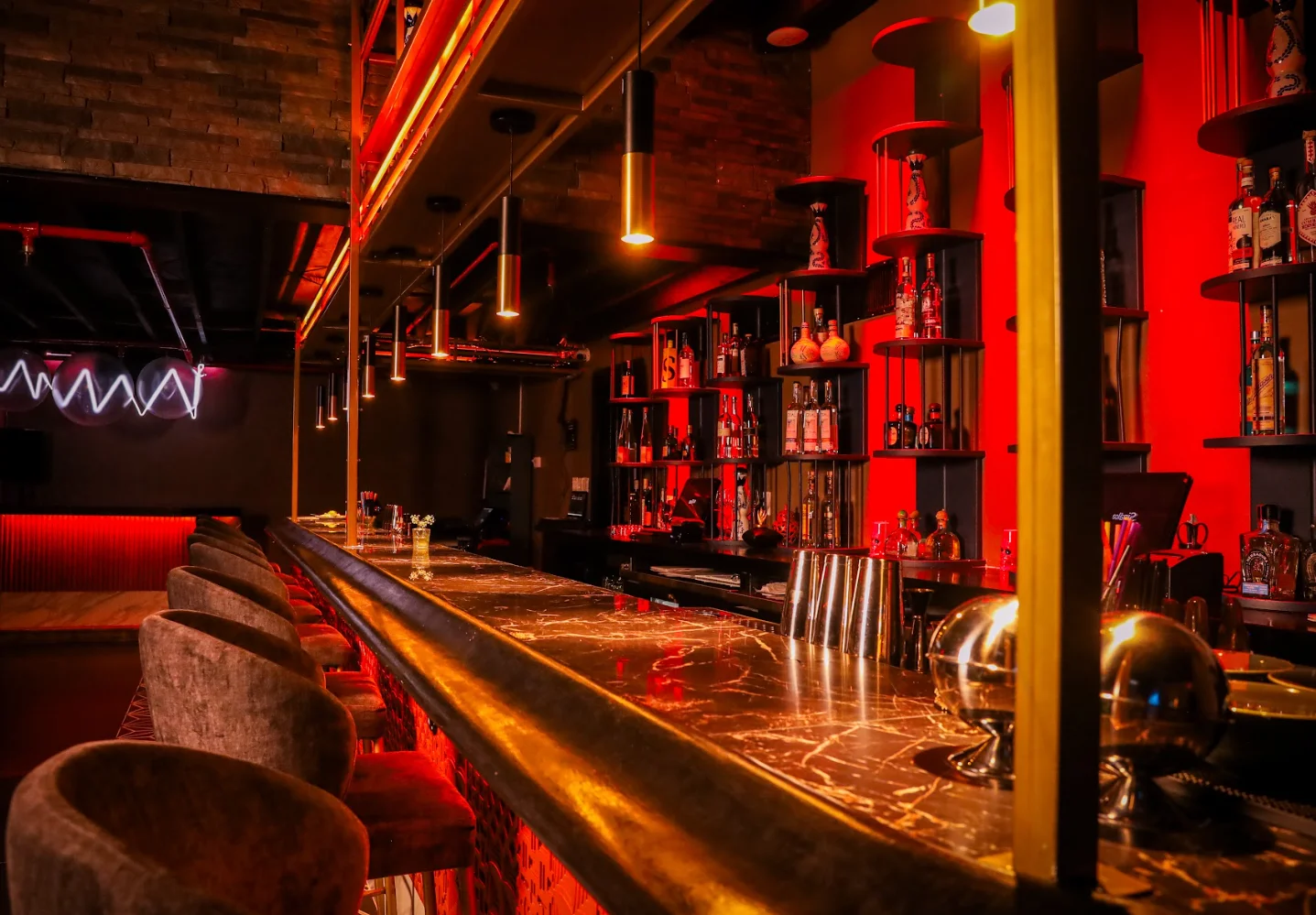 Stylish bar interior with modern lighting and shelves of spirits