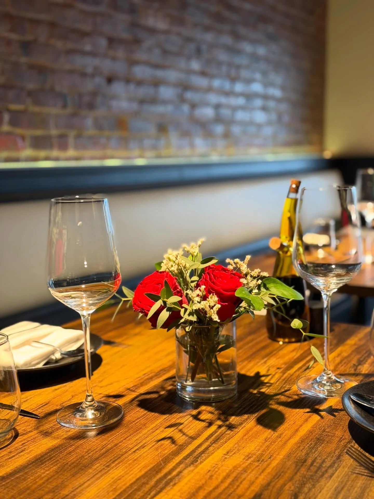 A neatly folded napkin on a small white plate, placed on a gray countertop in a restaurant setting.