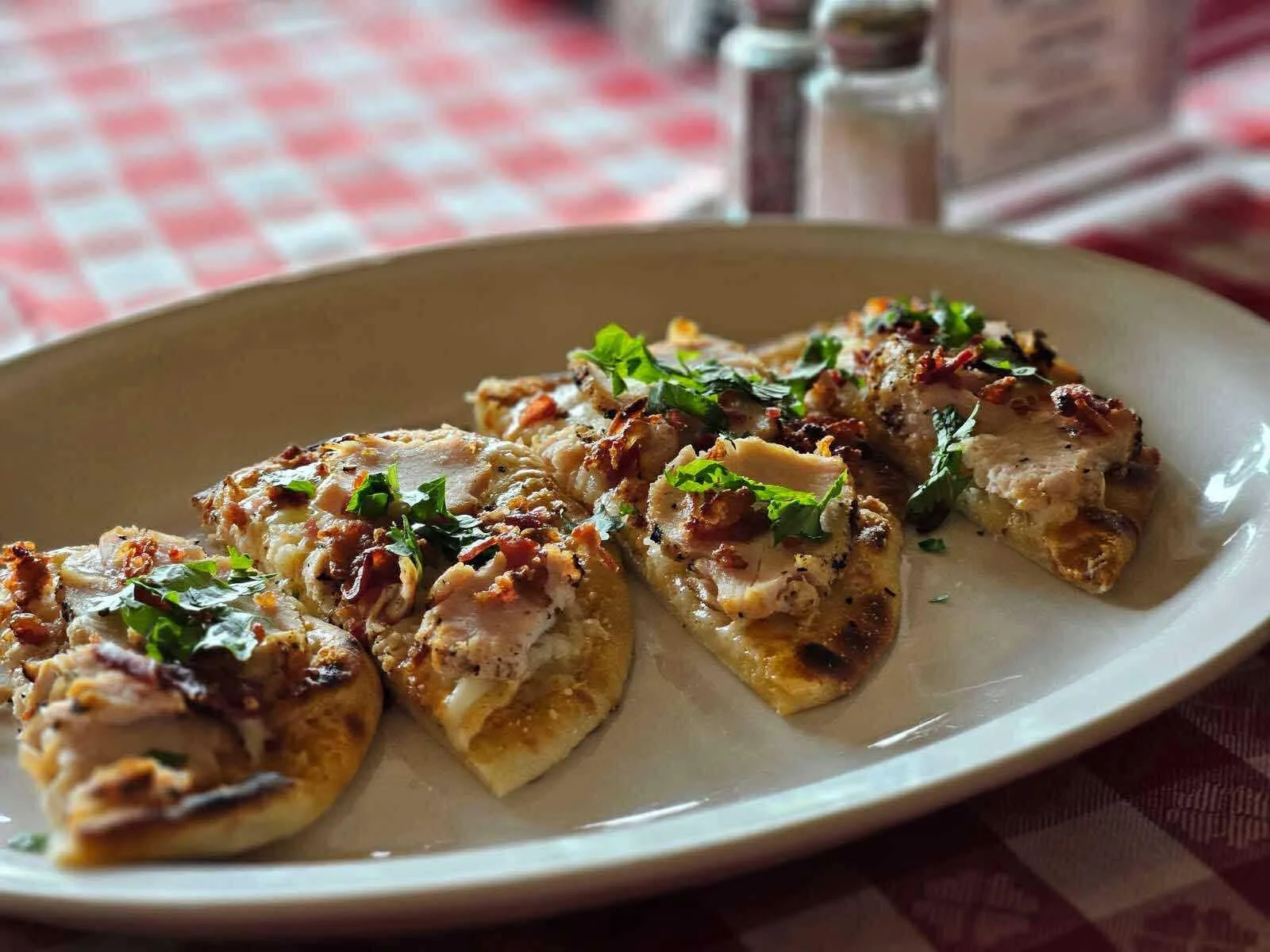 Grilled flatbread topped with chicken and herbs