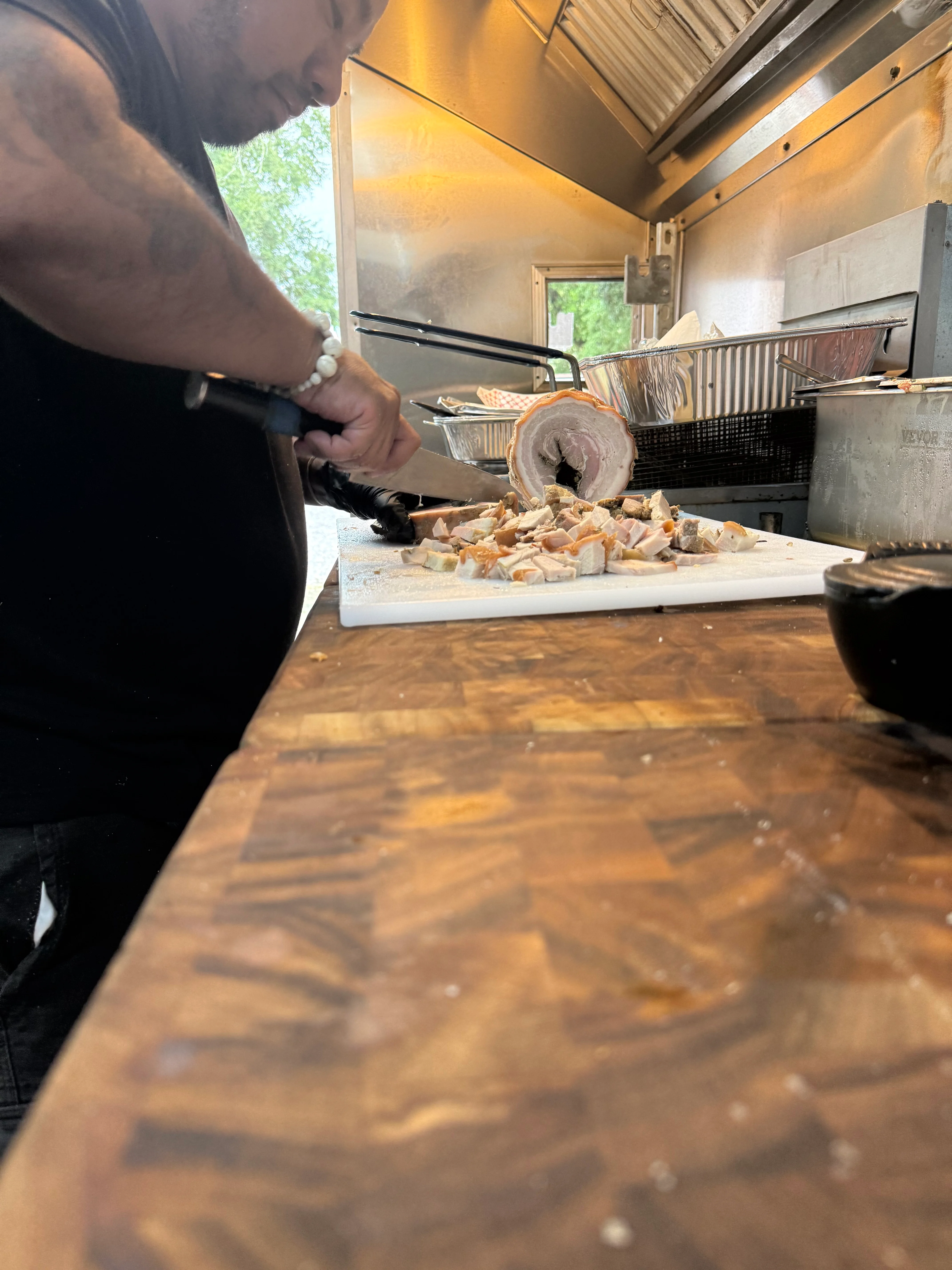 Chef slicing pork belly for tacos al pastor