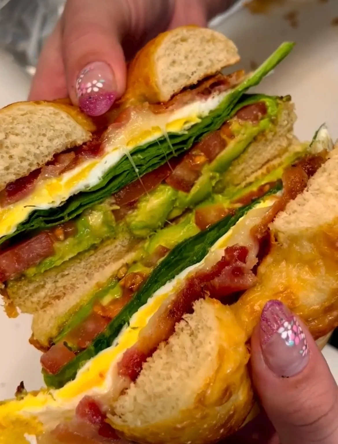 Layered breakfast sandwich with bacon and avocado