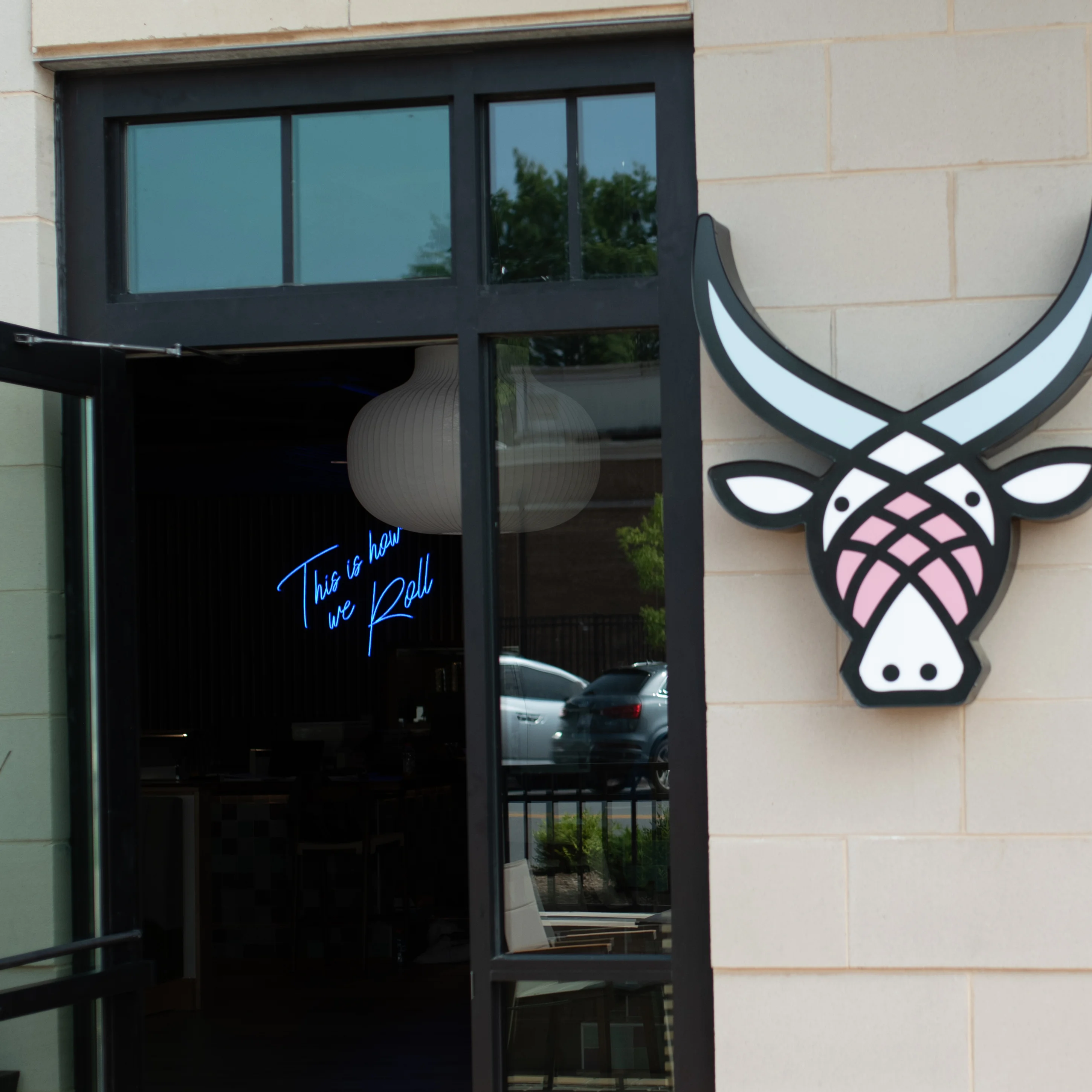 Restaurant entrance with neon sign and decorative bull head logo