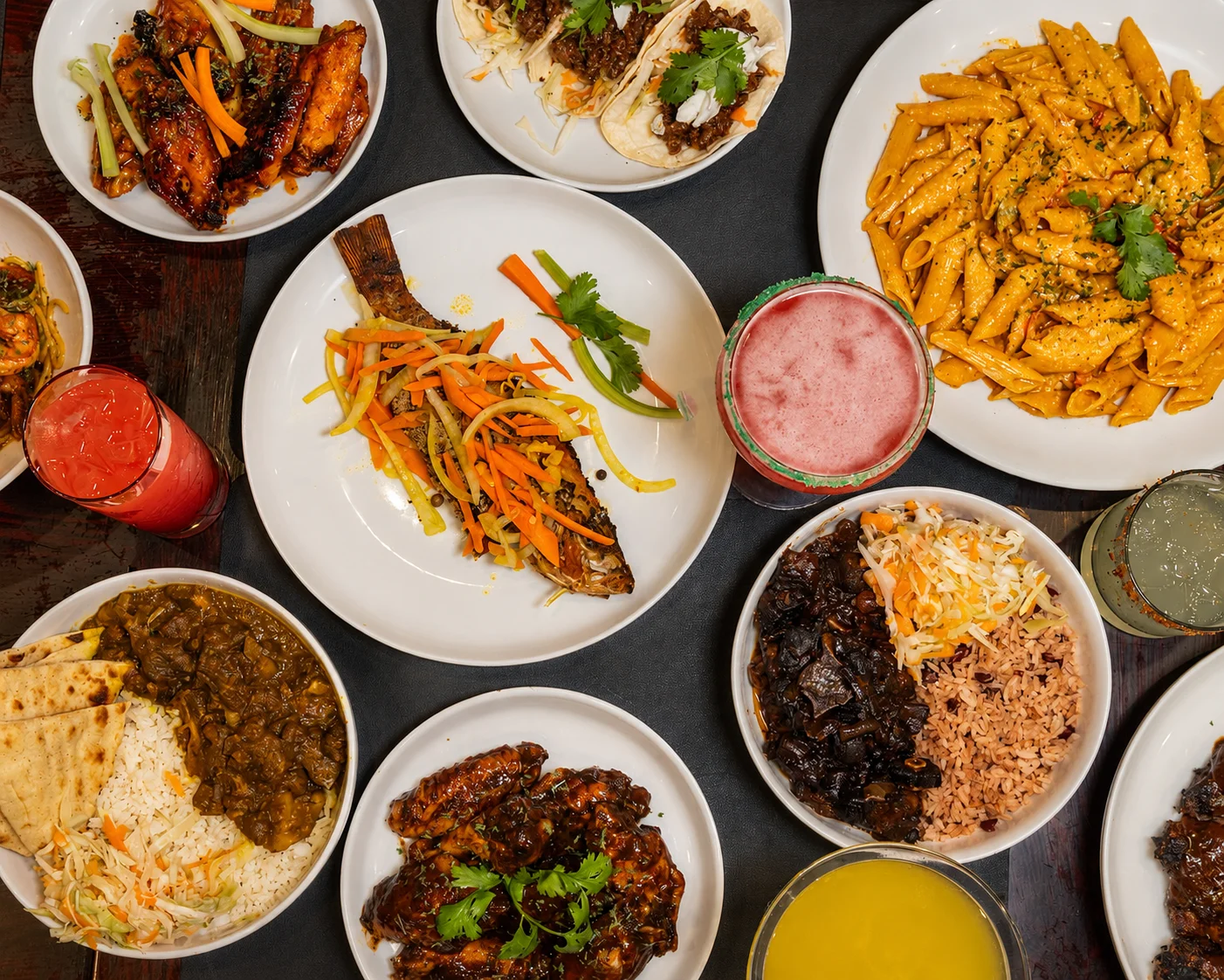 Assorted Caribbean dishes including jerk chicken and rice and peas