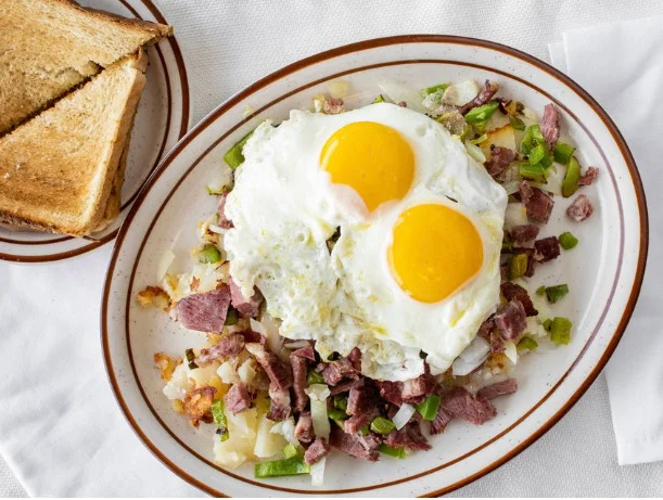 Classic American corned beef hash topped with sunny-side-up eggs