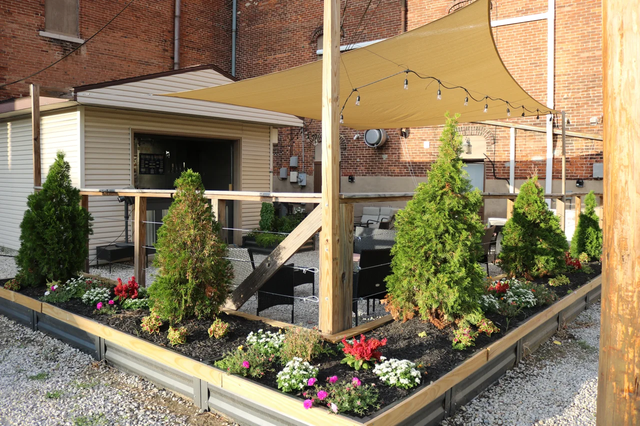 Outdoor dining area with shaded seating and landscaped garden