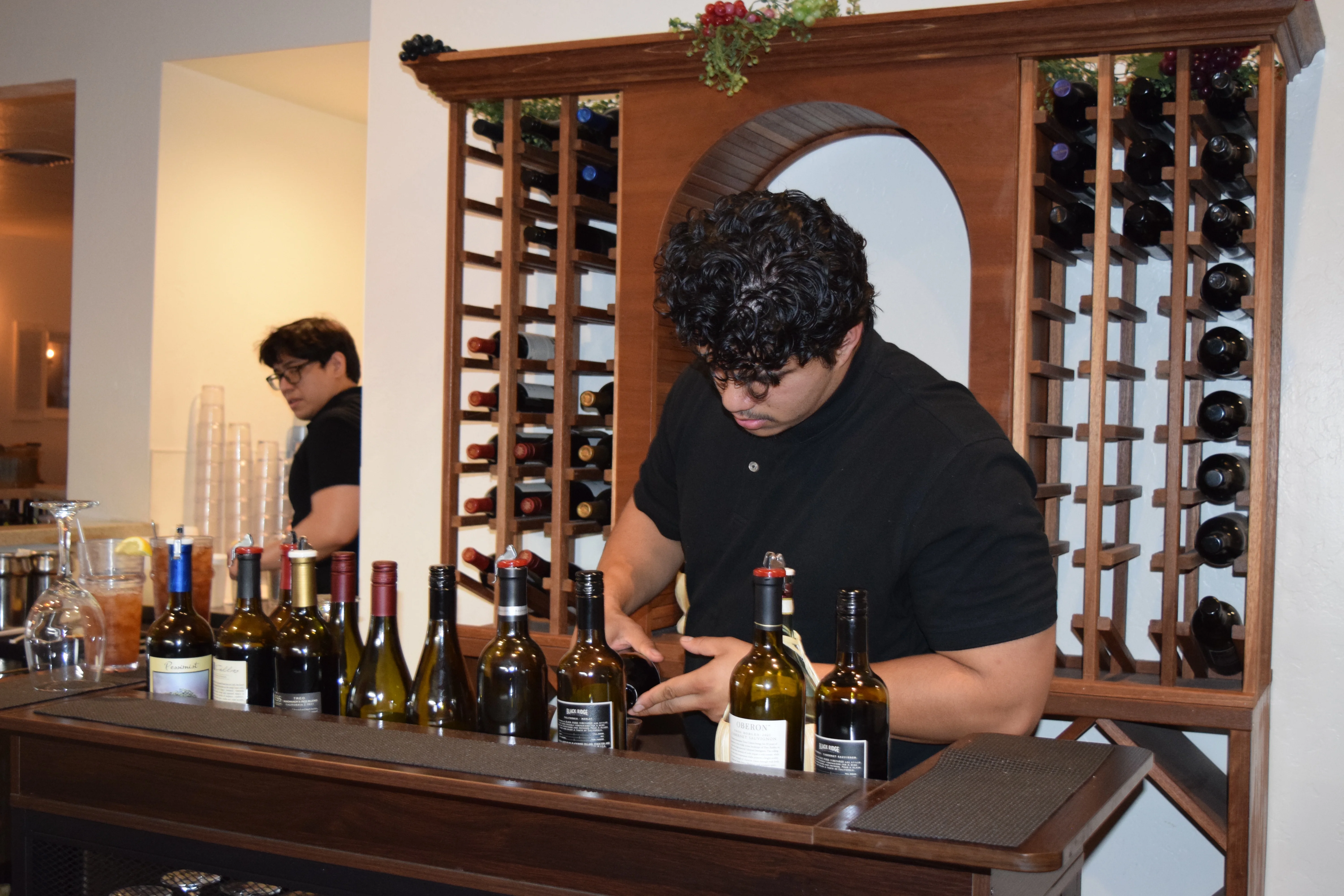 Bartender organizing wine bottles at a stylish bar