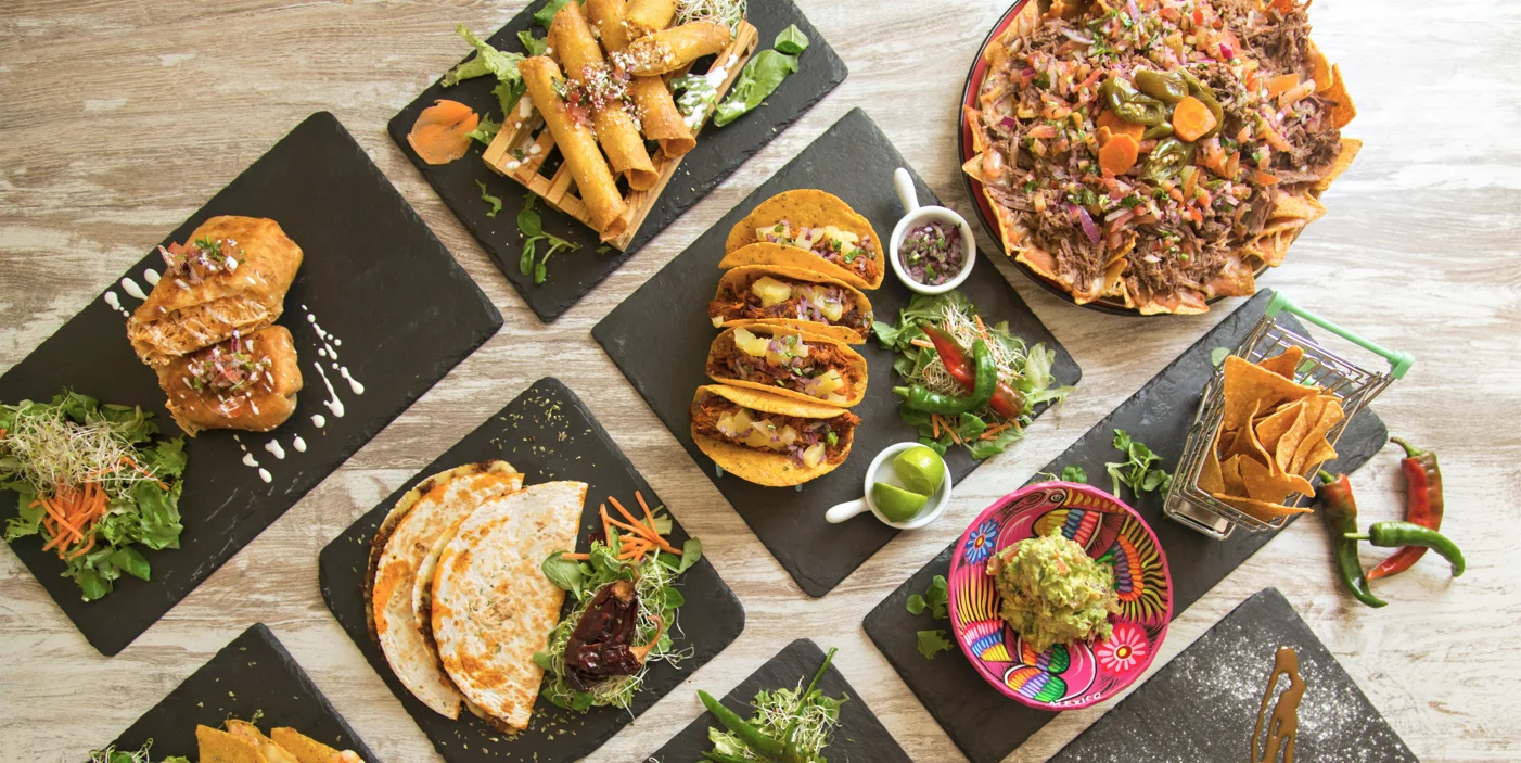 Colorful Mexican platter with tacos, guacamole, and nachos
