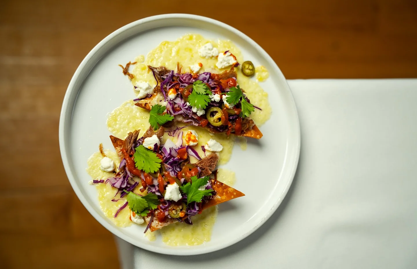 Mexican nachos topped with pulled meat and fresh garnishes