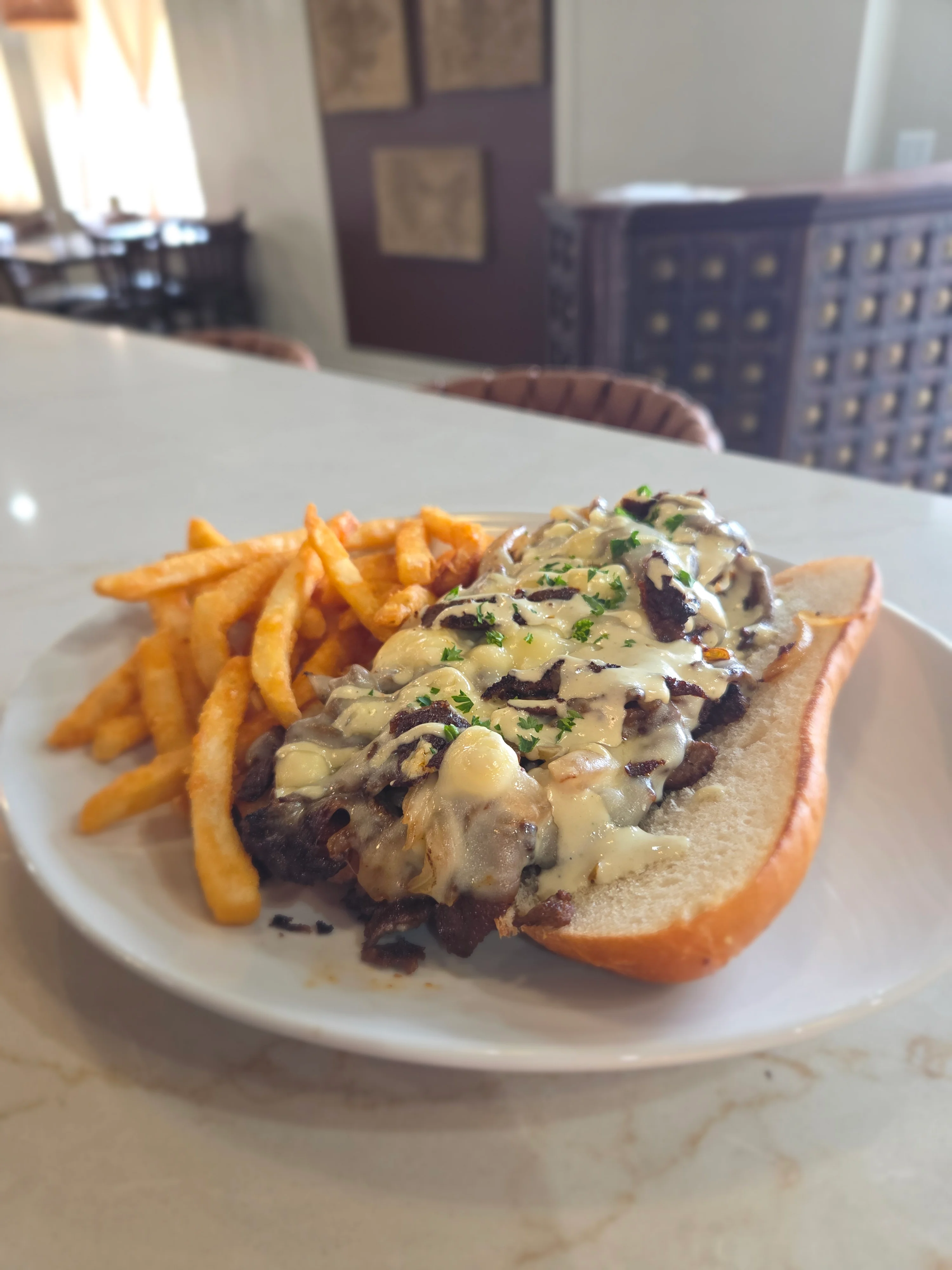 Philly cheesesteak sandwich with fries
