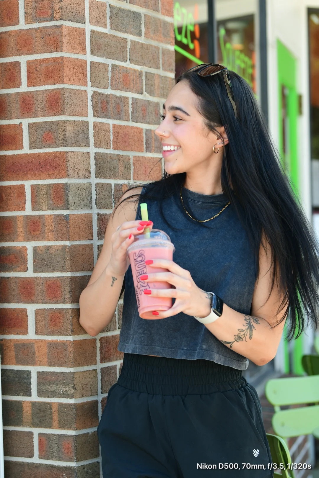 Young woman enjoying a refreshing smoothie outside a cafe