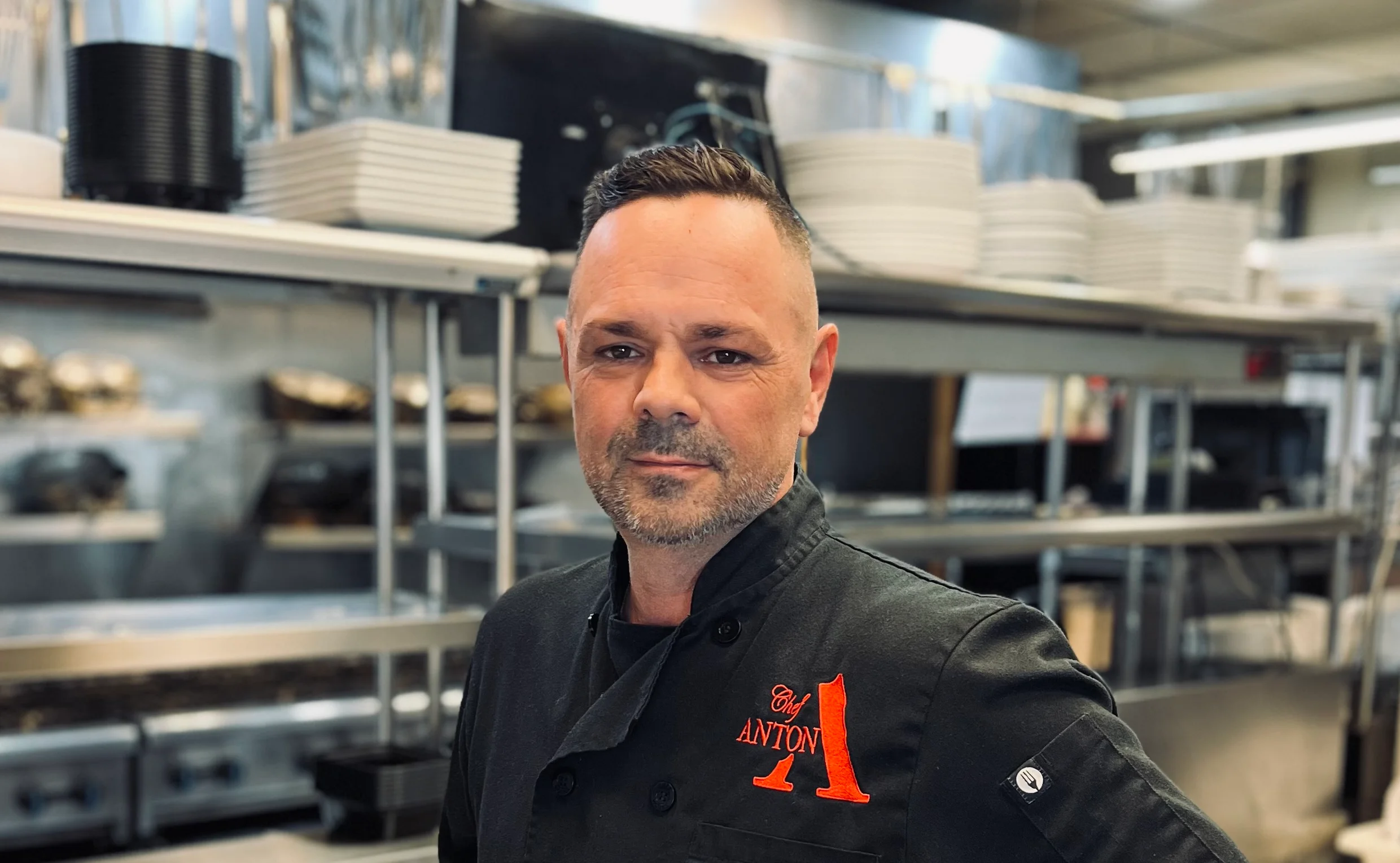 Chef in a professional kitchen wearing a black uniform