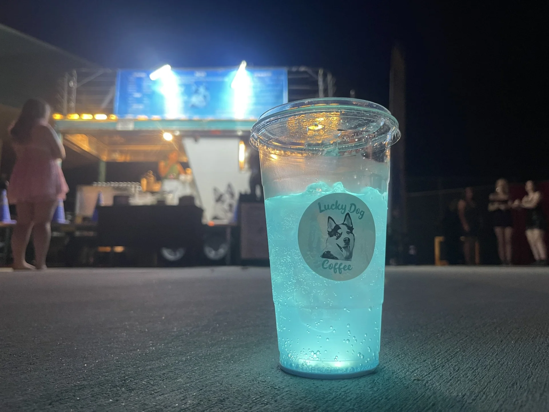 Vibrant blue drink in a clear cup at a food truck event