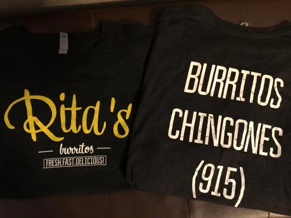 Two t-shirts displayed together, one featuring a fun slogan about burritos and the other the restaurant's logo.