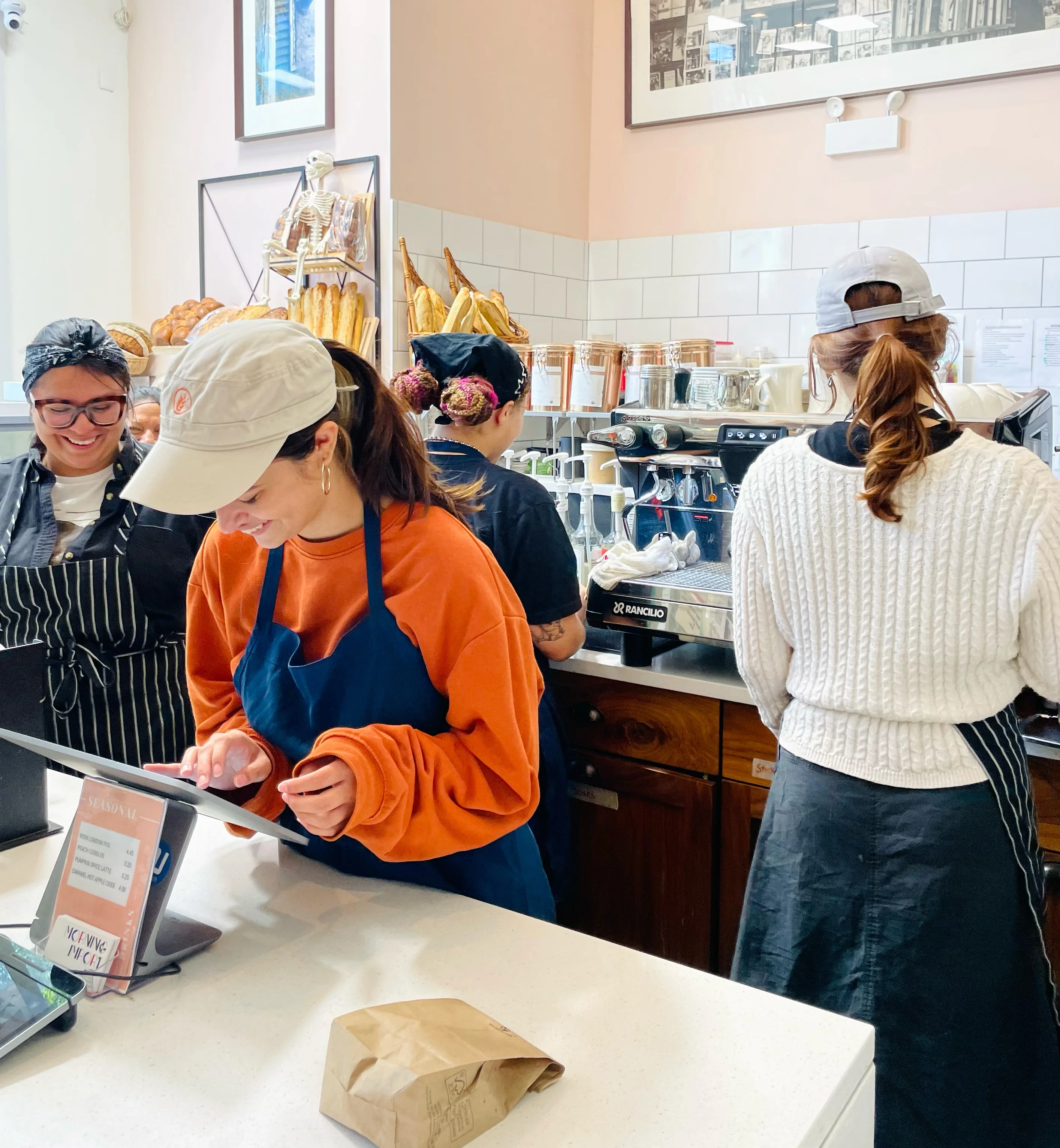 Friendly La Boulangerie & Co staff at the California location preparing coffee and fresh croissants.