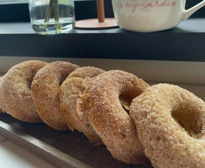 Freshly baked cinnamon sugar donuts on a wooden platter