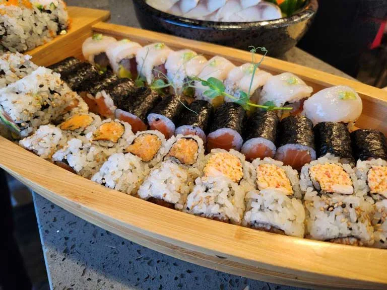 Various sushi rolls in a bamboo serving boat