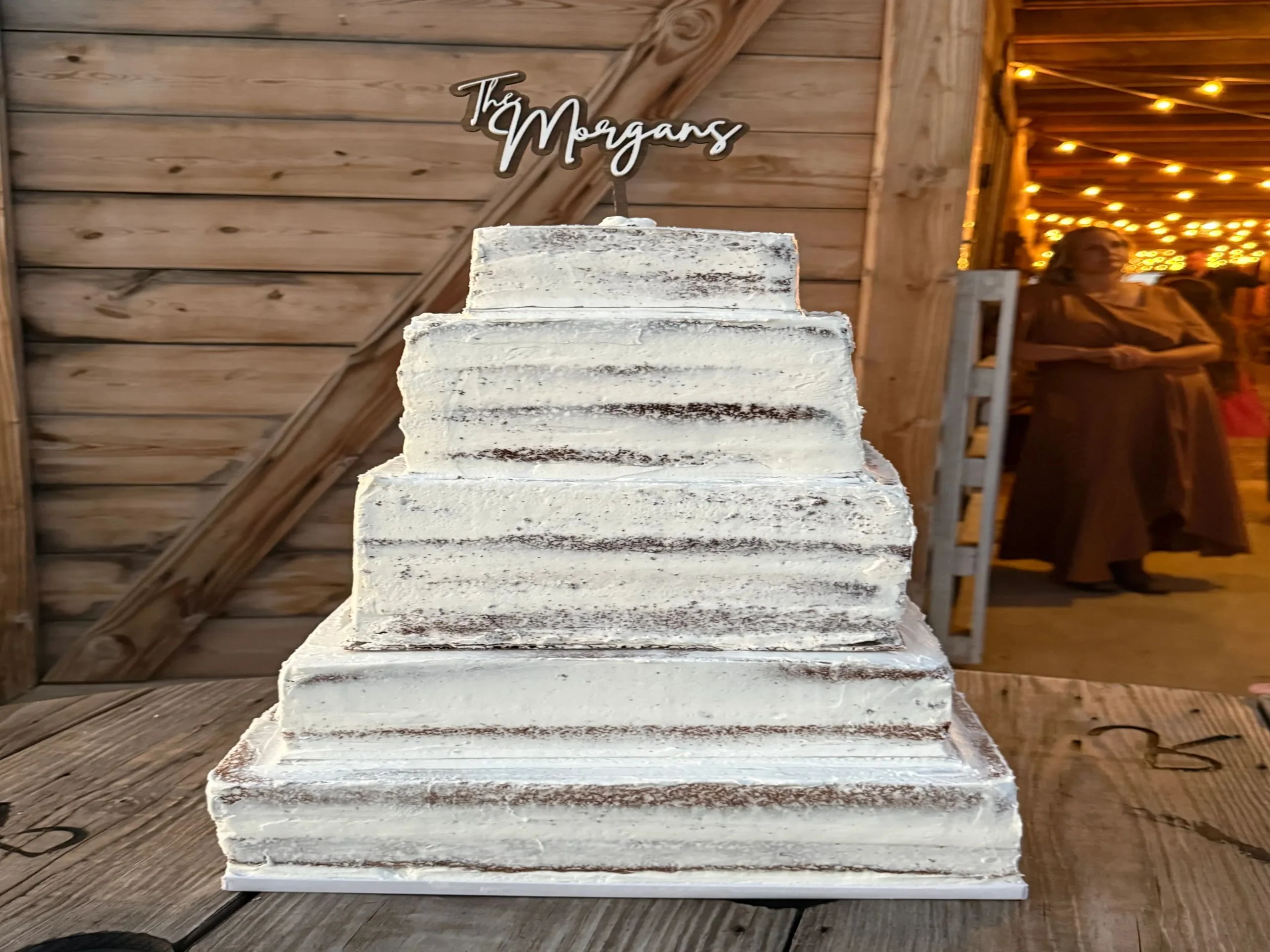 Elegant wedding cake with rustic design and personalized topper