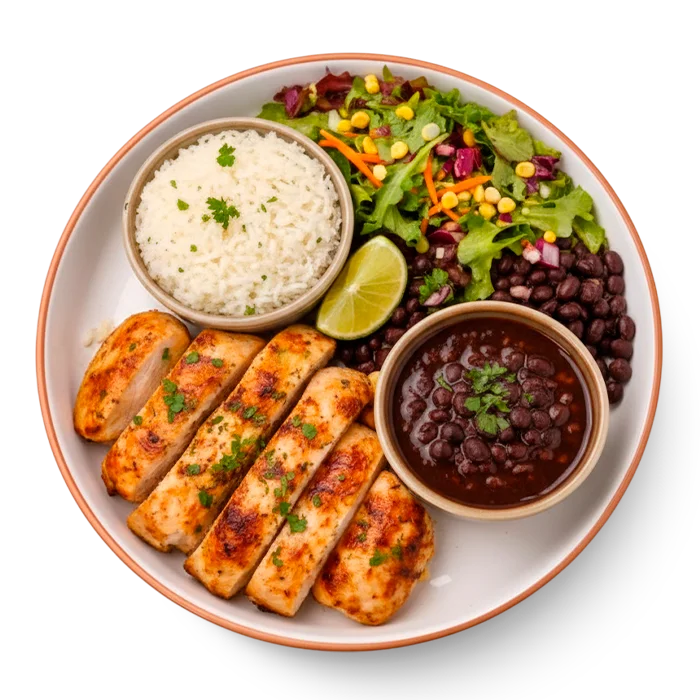 Plate of grilled chicken with sides of vegetables and rice