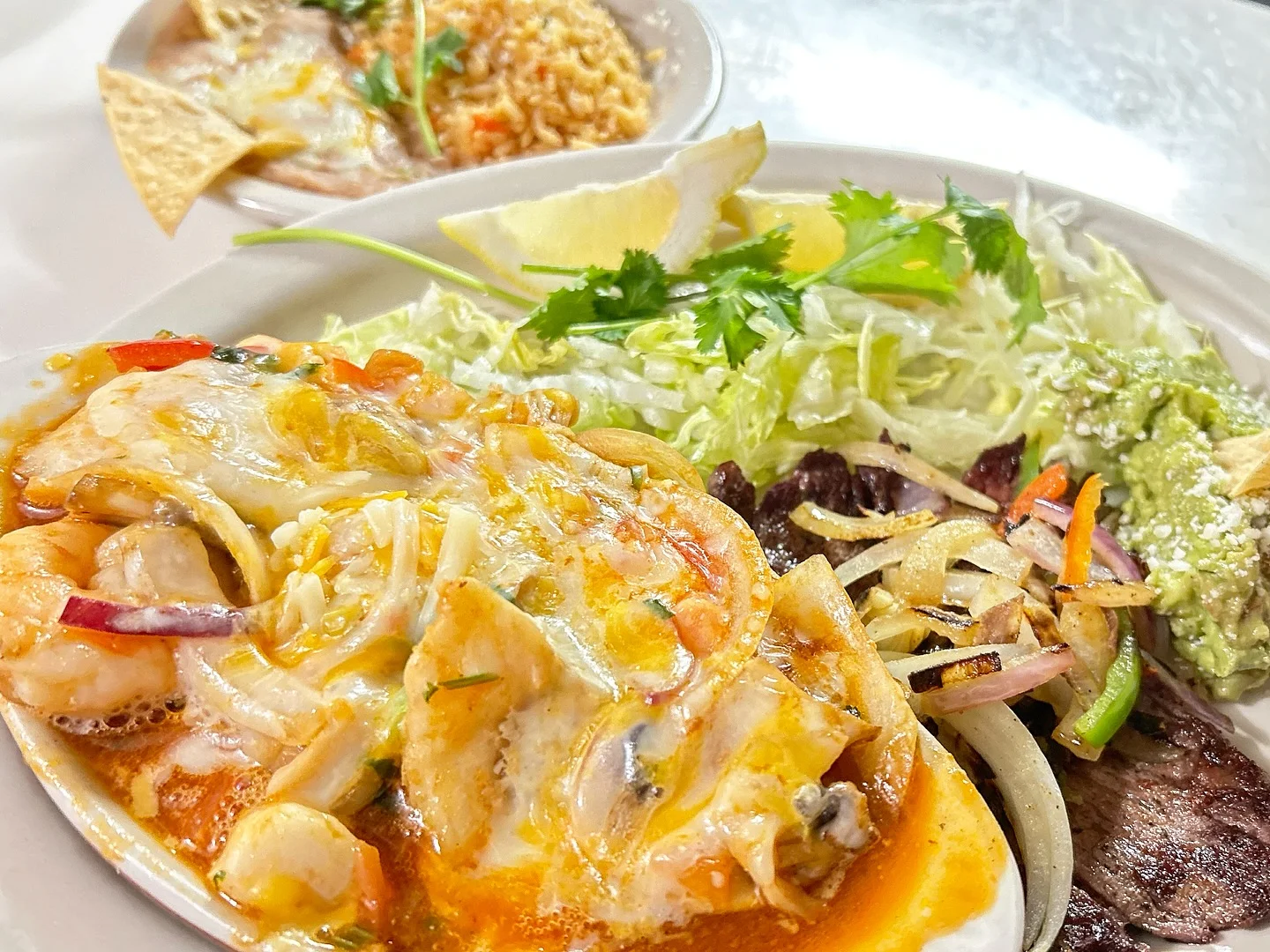 Delicious Mexican seafood enchiladas with guacamole and fresh salad