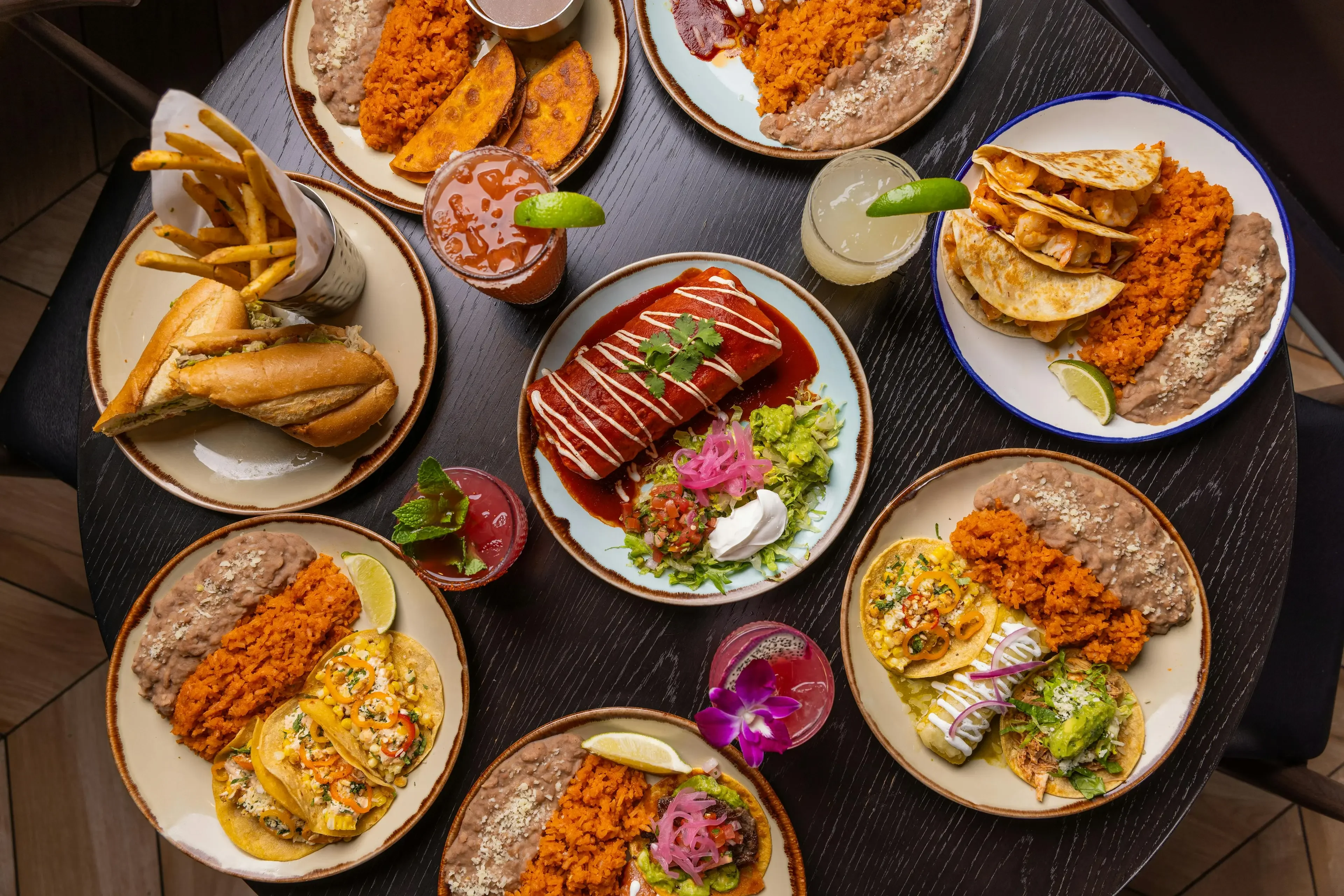 Colorful Mexican feast with tacos, enchiladas, and drinks