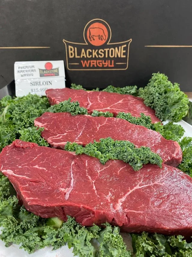 Premium American Wagyu sirloin steaks on a bed of kale