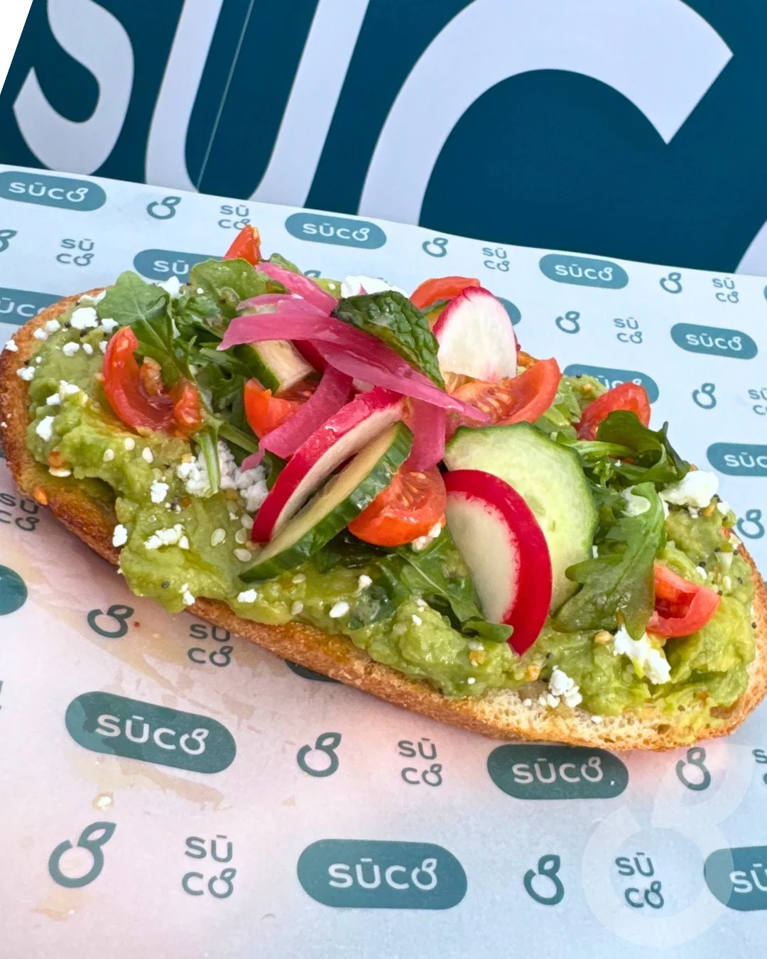 Avocado toast topped with fresh vegetables