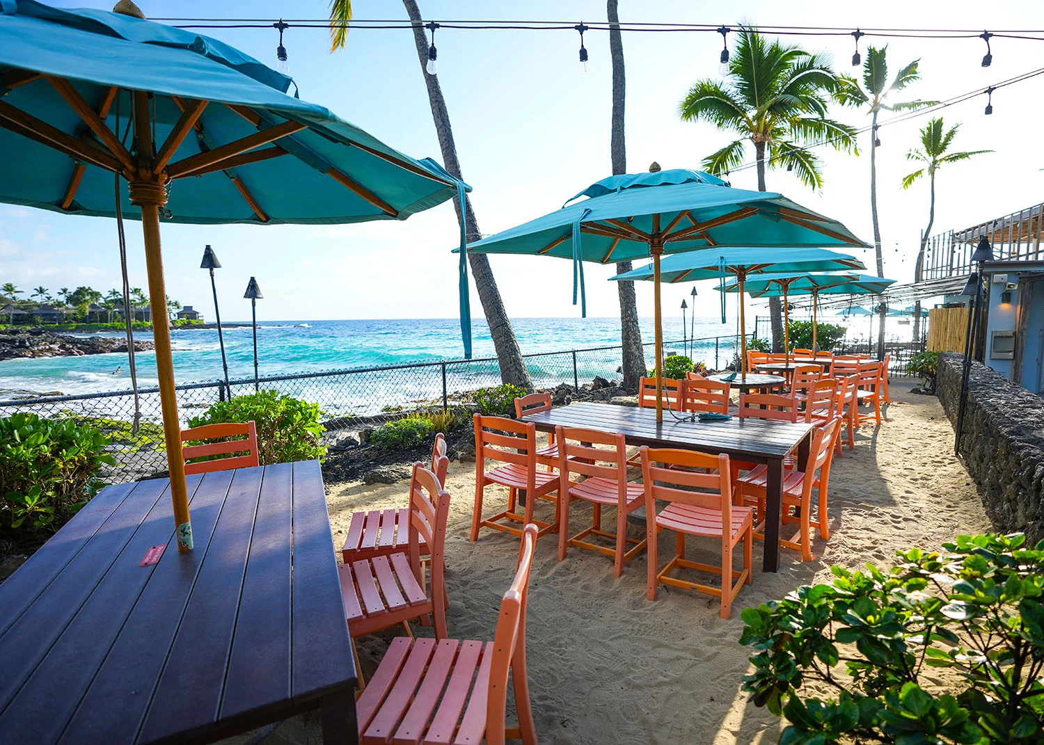 Outdoor dining area by the beach with colorful umbrellas