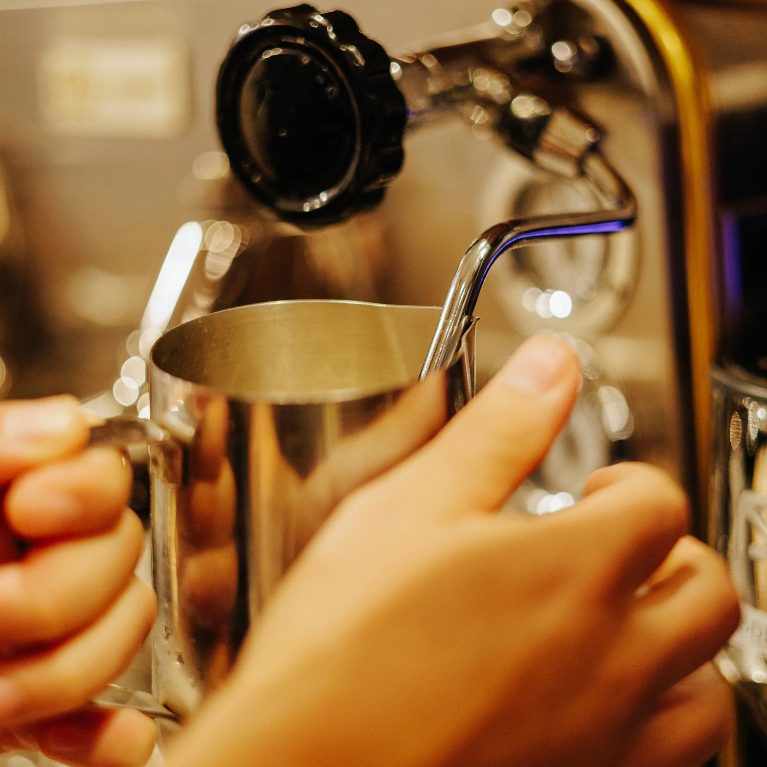 Barista steaming milk for coffee drinks