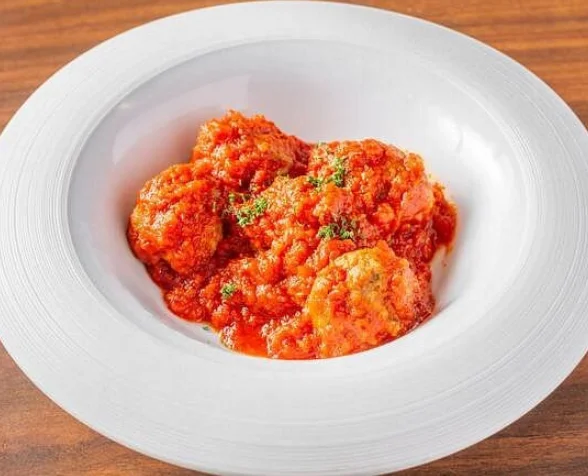 Italian meatballs in marinara sauce served in a white bowl